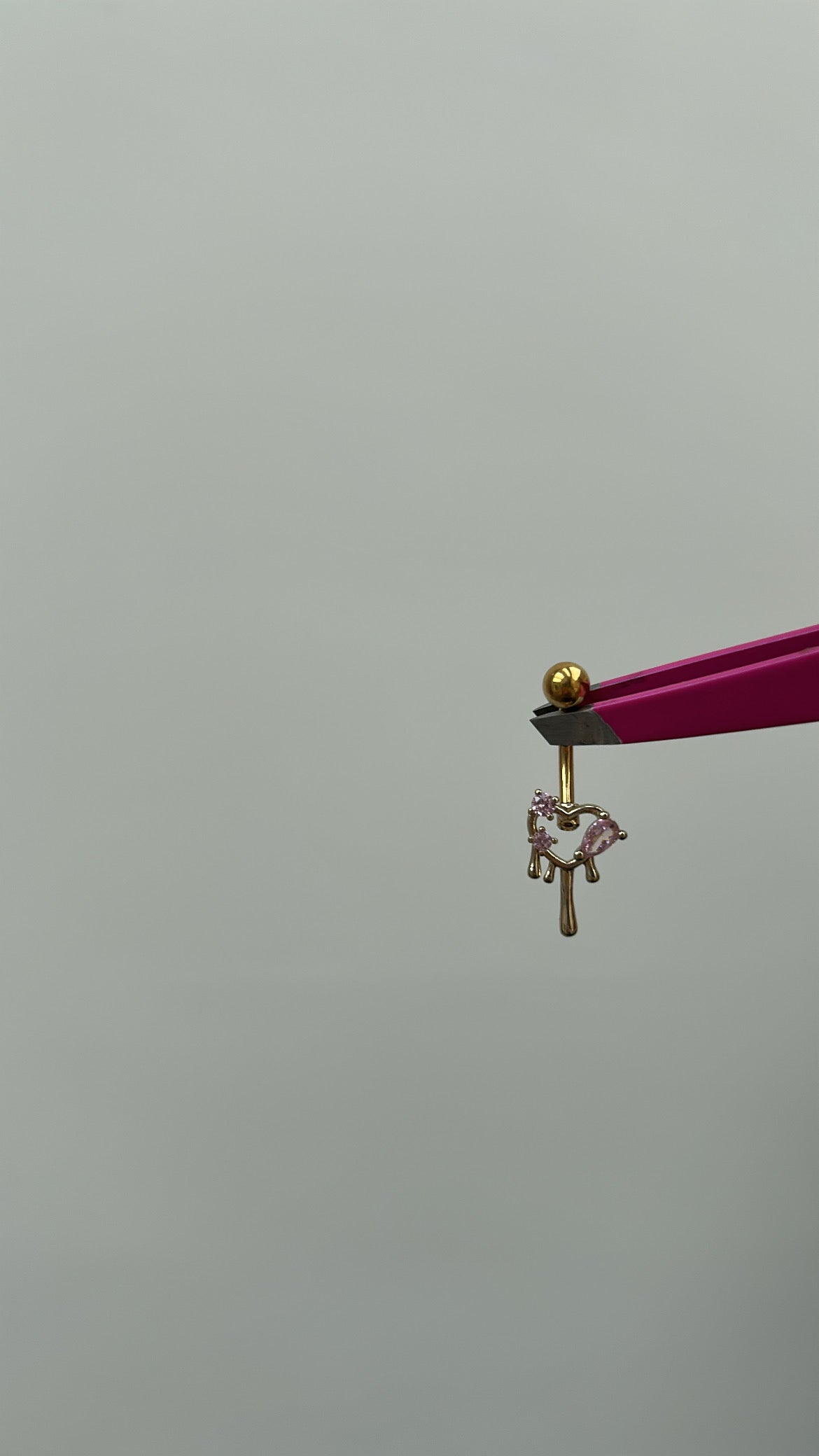 Gold liquid style belly bar with pink detailing